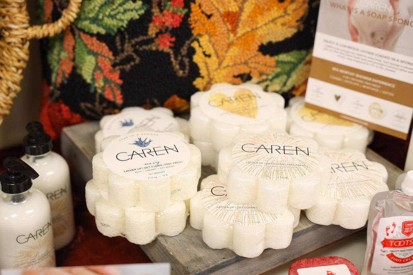 Caren flower-shaped soaps stacked beside Caren lotions