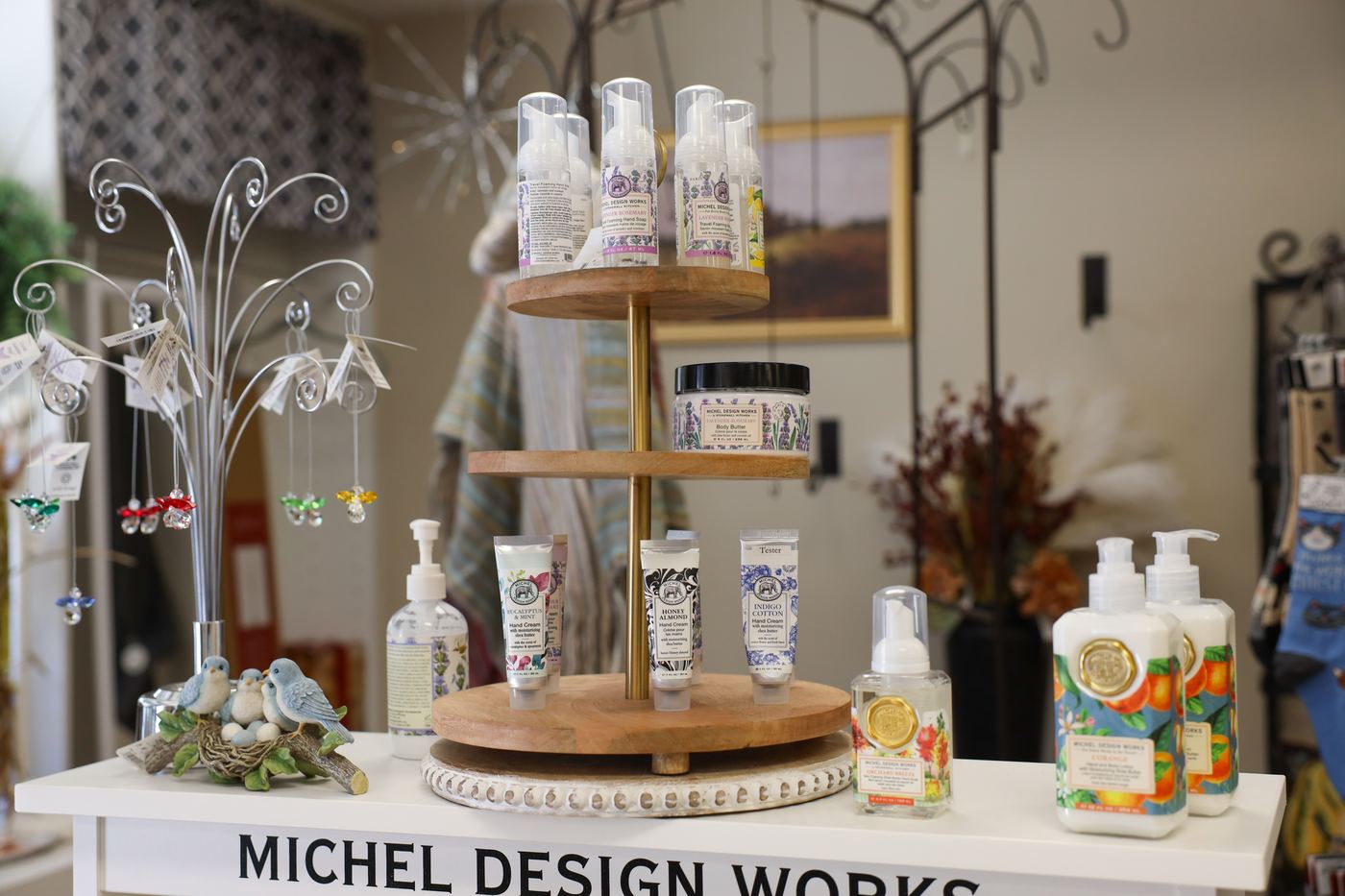 A tiered Michel Design Works stand of hand creams and lotions
