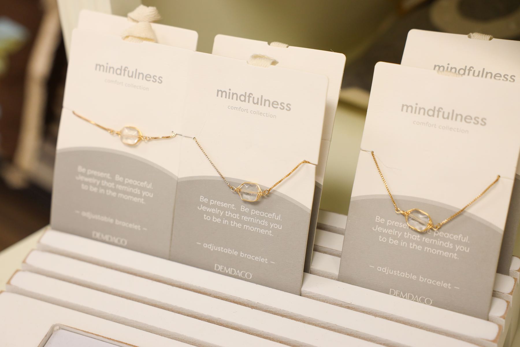 Delicate gold necklaces displayed on their Mindfulness message cards