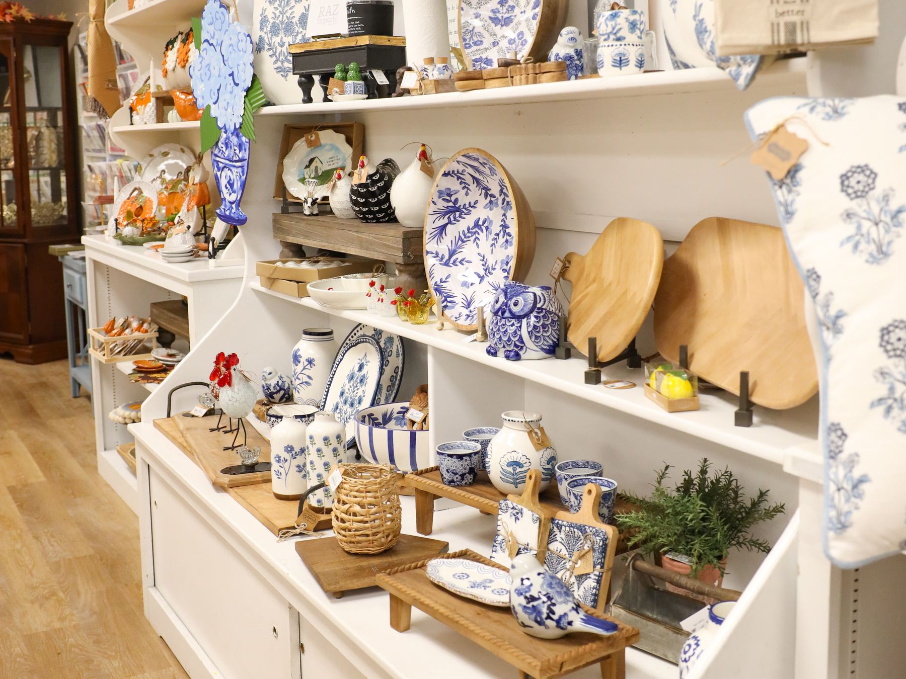 Blue and white ceramics, serving pieces, and wooden boards on the shop's shelves
