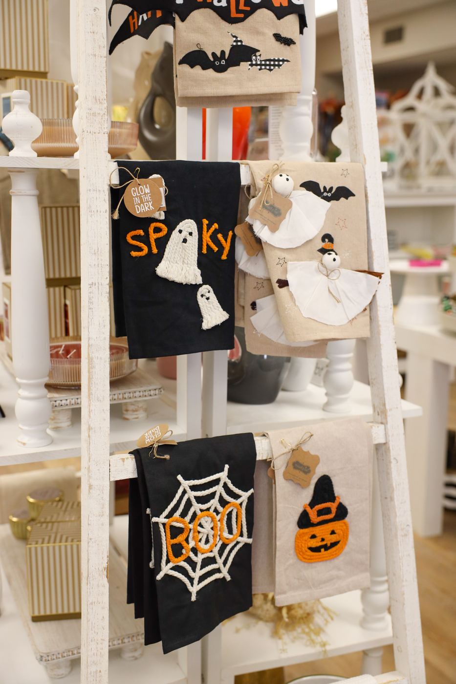 Halloween tea towels with ghosts and spiderwebs on a ladder display