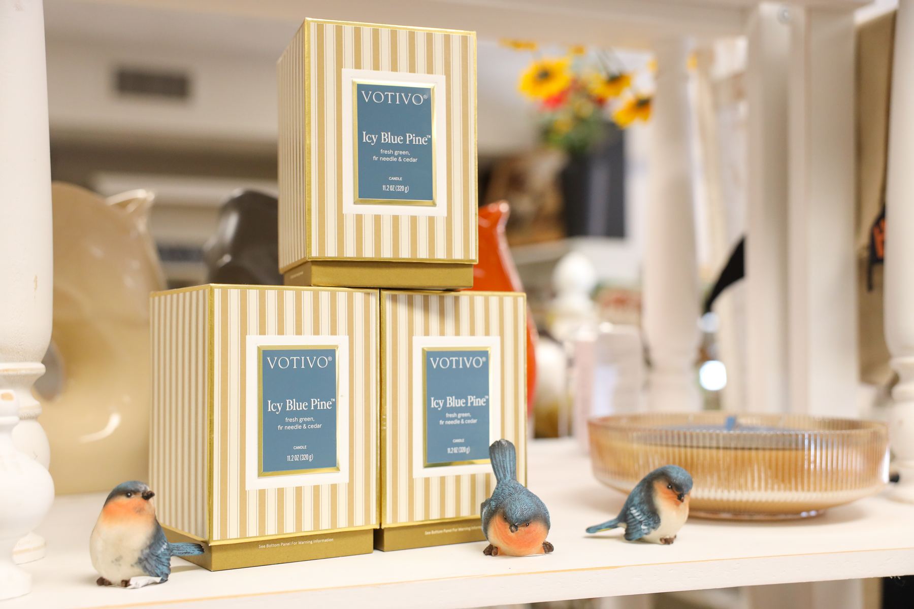 Votivo Icy Blue Pine candles in striped gift boxes with bluebird figurines