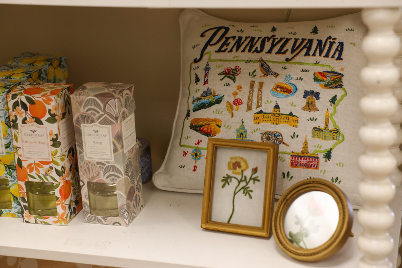 A Pennsylvania tapestry pillow with framed botanical prints and floral gift boxes